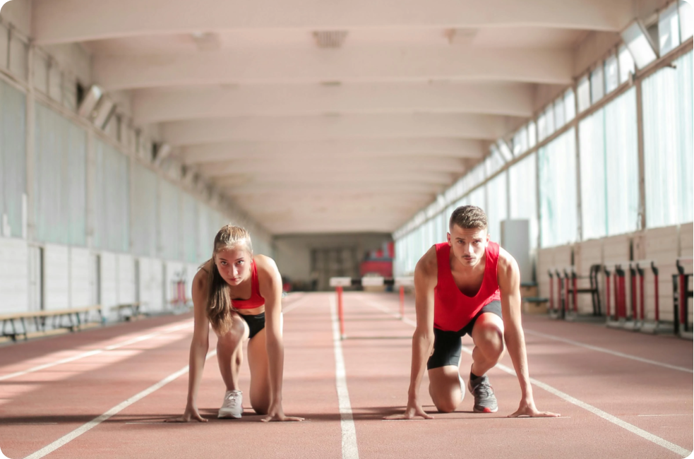 Deux athlètes sur la ligne de départ d'un sprint, prêts à partir. 